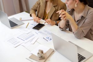 Doradca z domu maklerskiego omawia strategię inwestycyjną z klientem w nowoczesnym biurze.